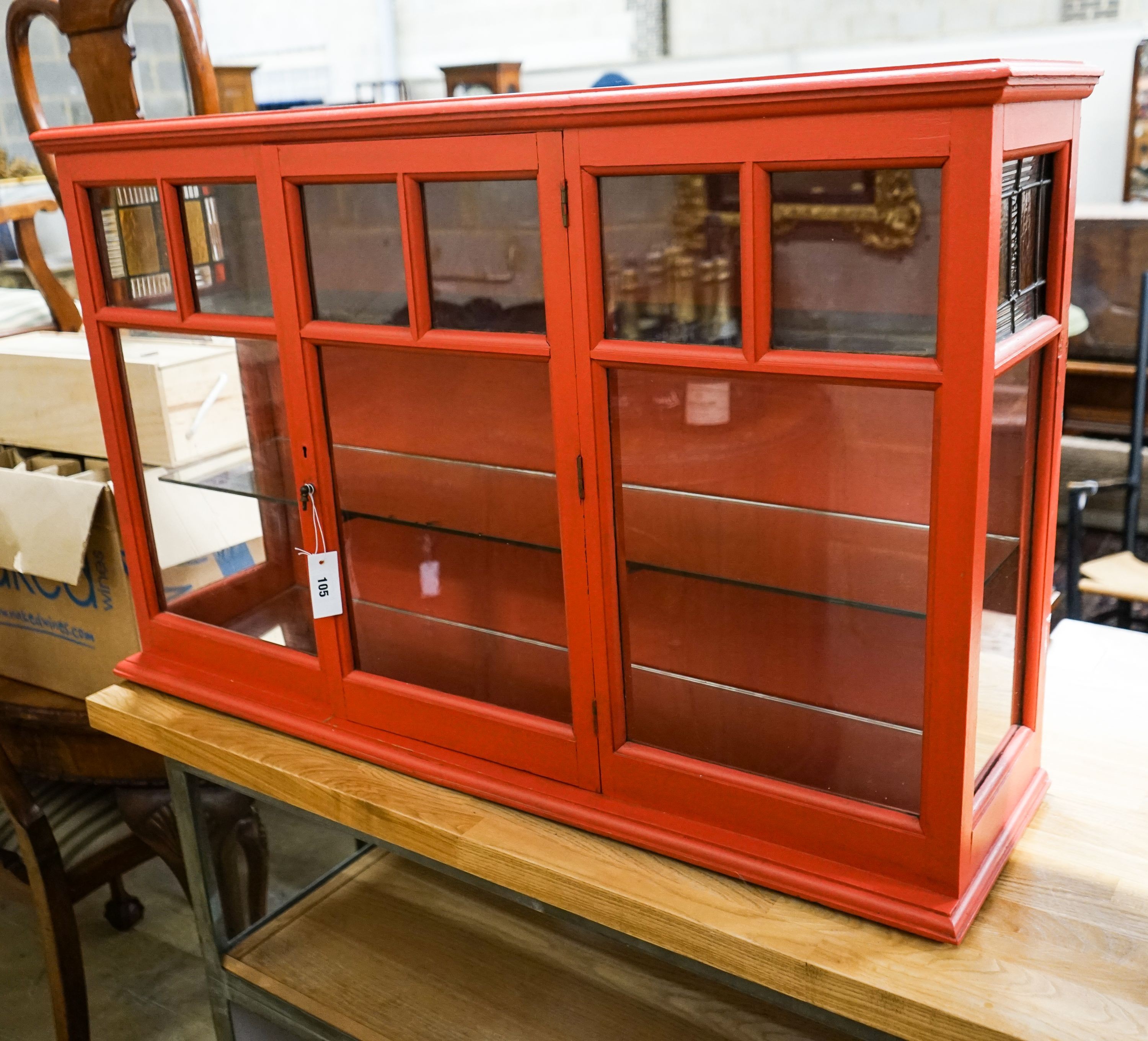 A painted glazed two door wall cabinet with mirrored interior, width 109cm, depth 26cm, height 68cm